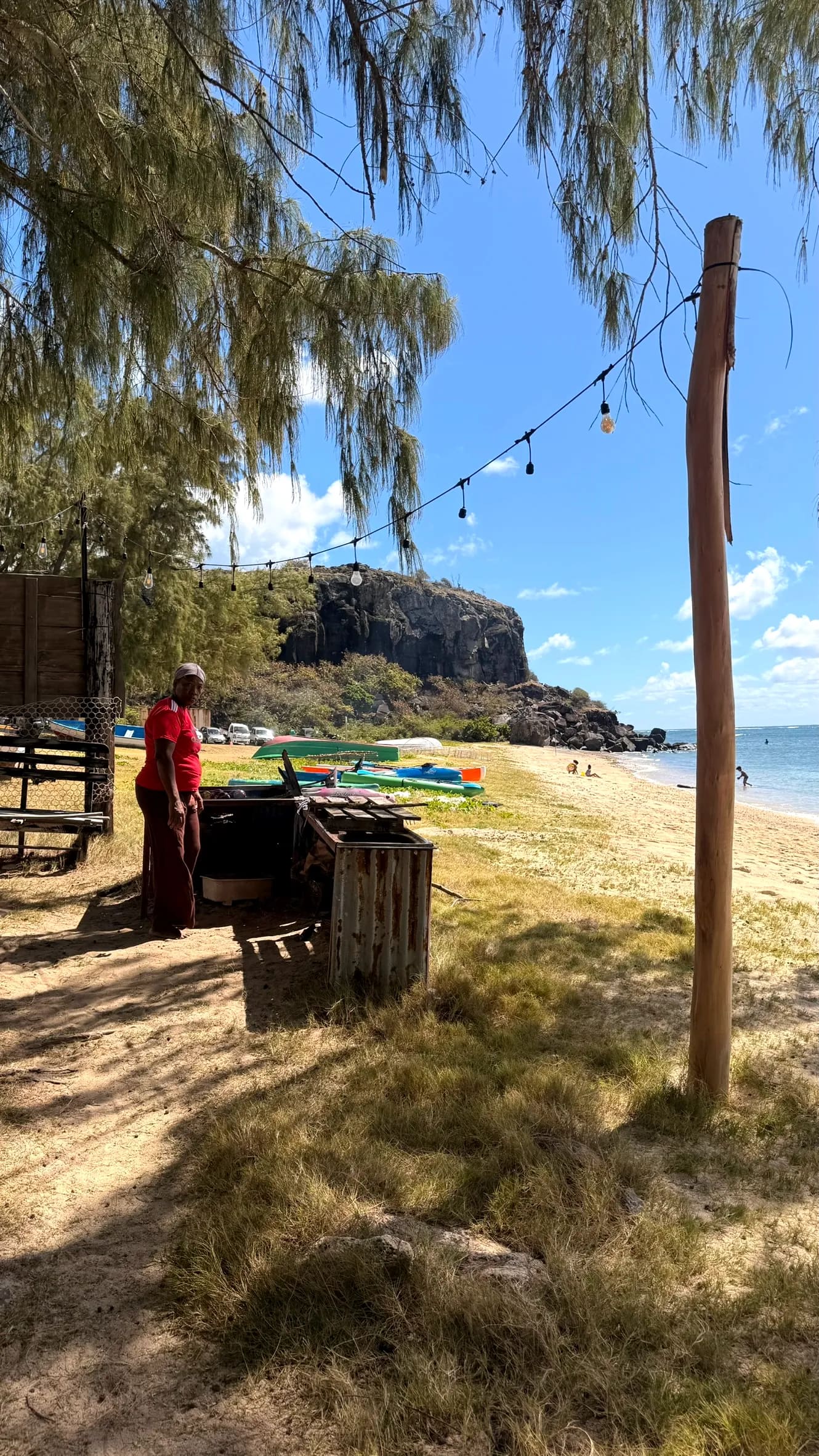 Le barbecue d'Otentika et les kayaks colorés alignés au fond, à Rivière Banane