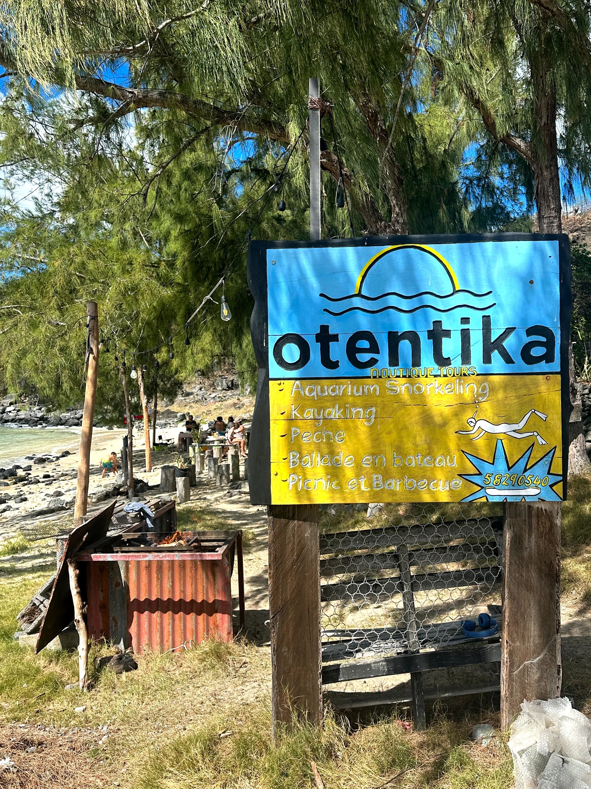 Pancarte bleue et jaune d'Otentika annonçant kayak, snorkeling et repas à Rivière Banane